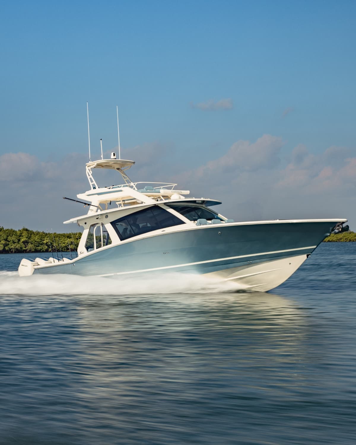 Sport-fish yacht running across calm coastal water