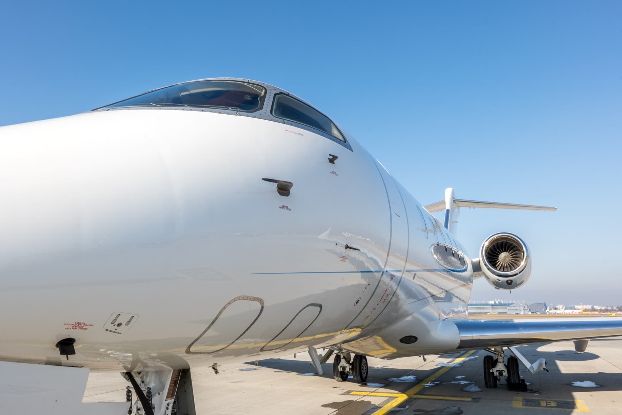 Front three-quarter view of the Challenger 300 on the ramp under a blue sky