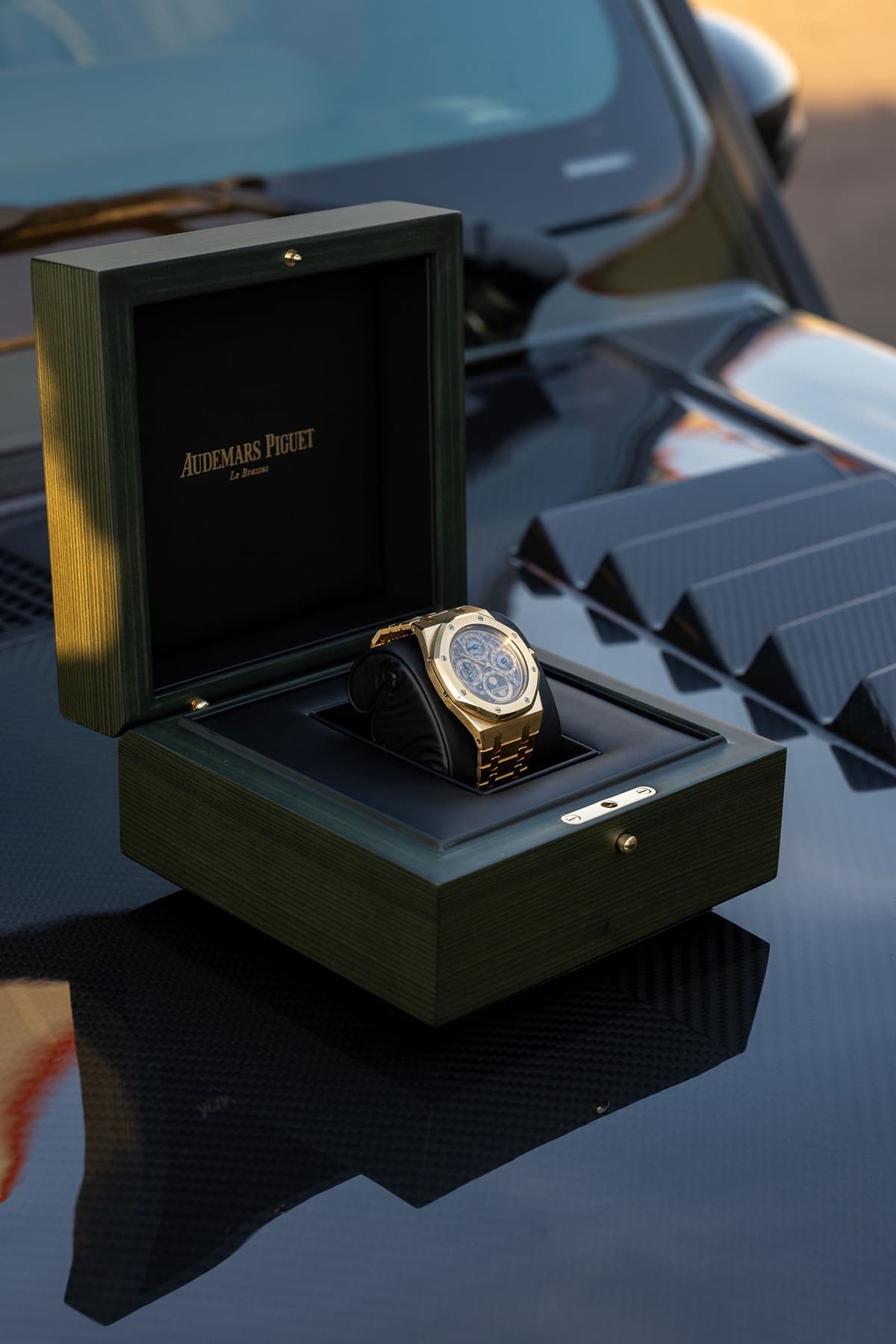 Gold Audemars Piguet in green presentation box on carbon fiber hood