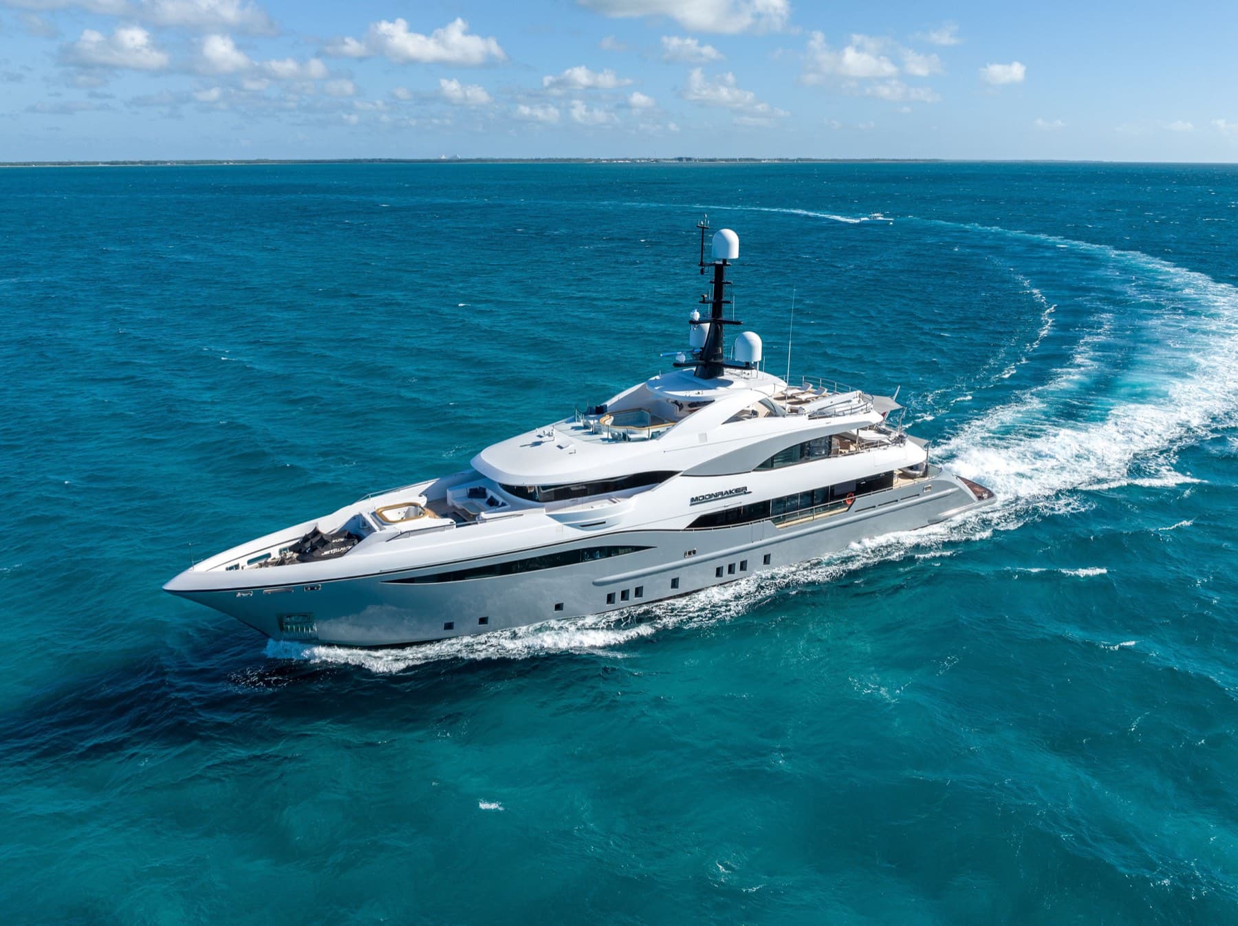 Superyacht Moonraker carving a turquoise wake across open Bahamian water